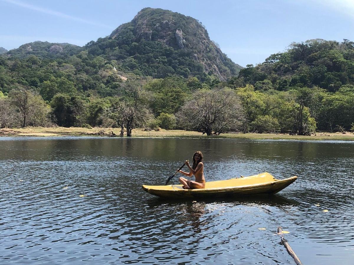 Paddling a yellow canoe across the lake, a granite mountain behind