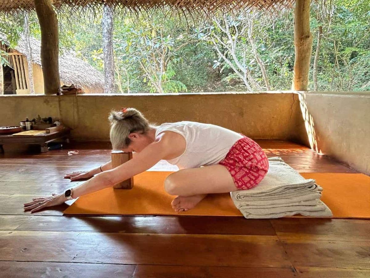 Guests in child's pose in the open-air yoga shala at Ulpotha.