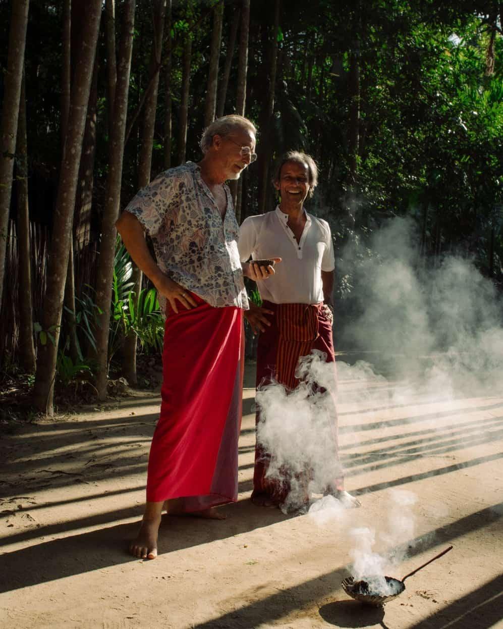 Founders Giles Scott and Viren Perera on a sandy path between tall trees at Ulpotha.