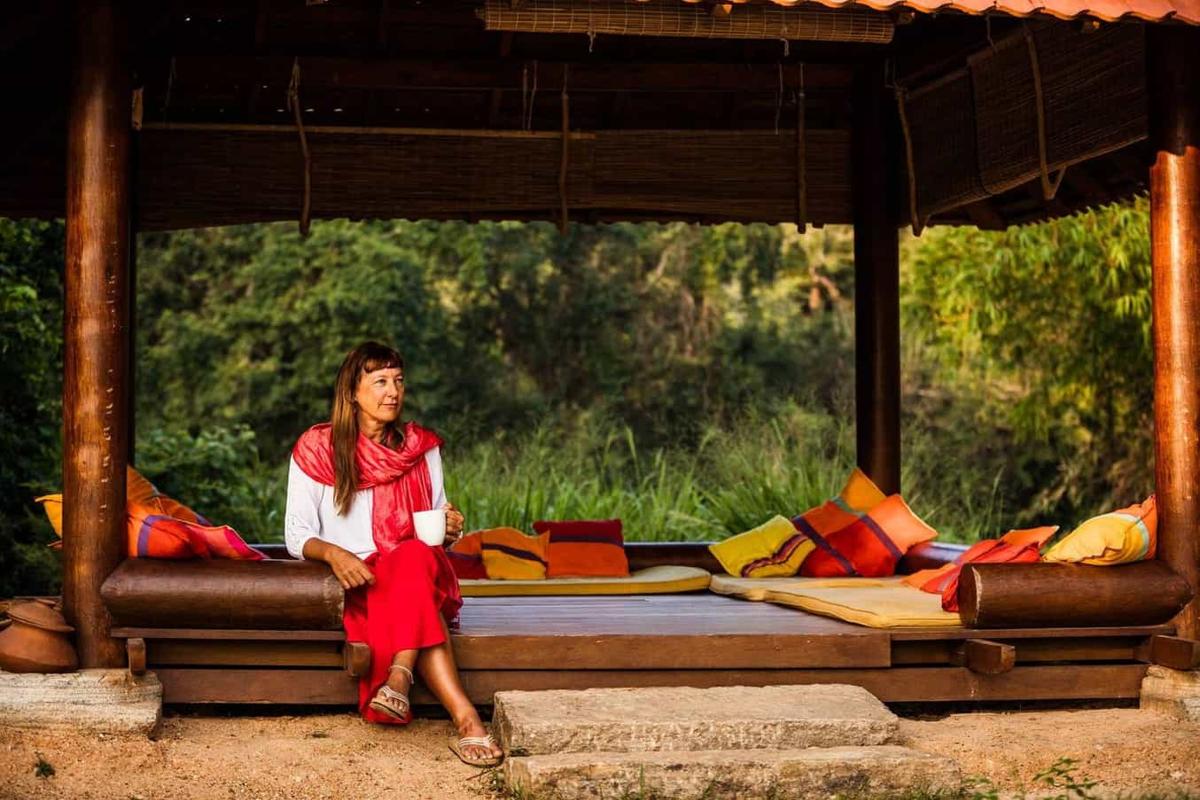 A guest with morning tea in a lakeside pavilion at Ulpotha.